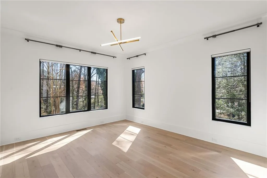 Spare room featuring visible vents, baseboards, light wood-style flooring, and a healthy amount of sunlight