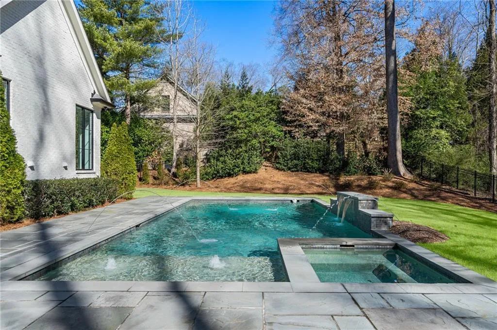 View of pool with a fenced in pool, a lawn, and an in ground hot tub