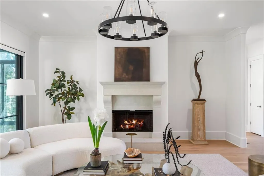 Living area featuring recessed lighting, a lit fireplace, crown molding, and wood finished floors