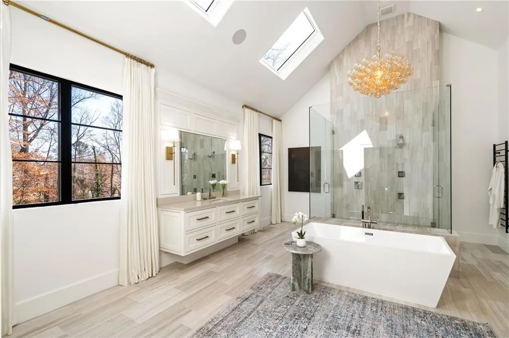 Full bath featuring a skylight, a shower stall, wood finished floors, and vanity