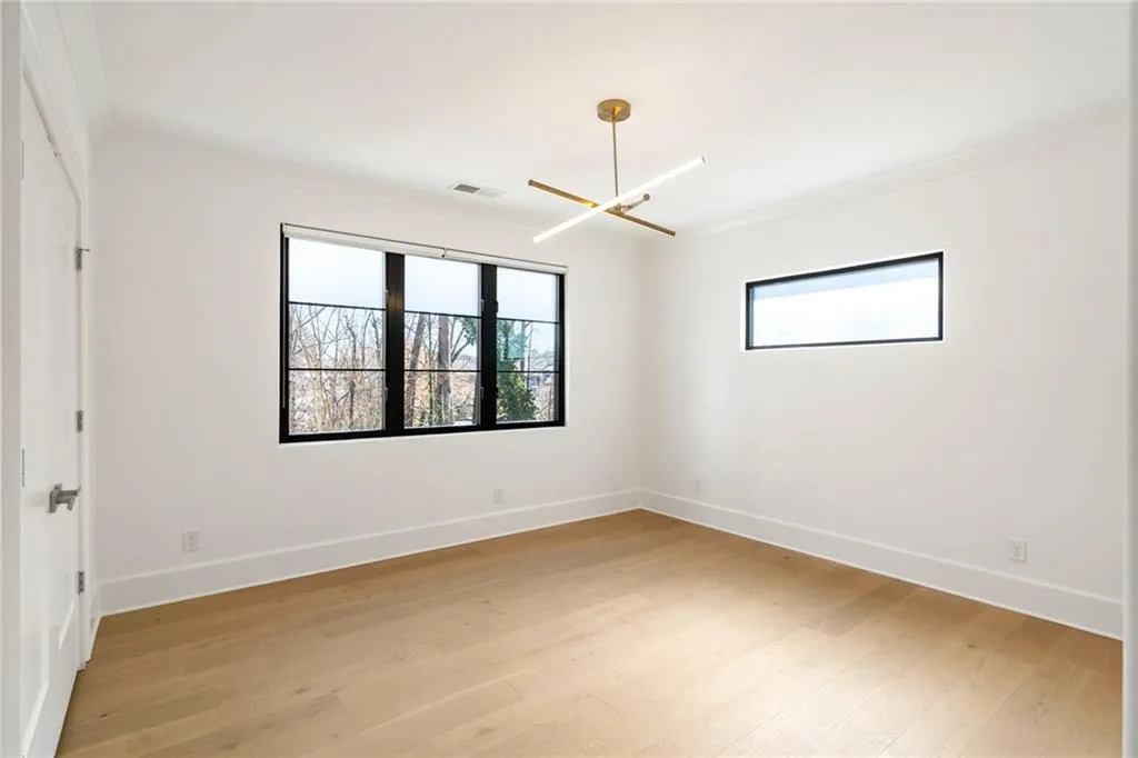 Unfurnished room with ornamental molding, baseboards, visible vents, and light wood finished floors