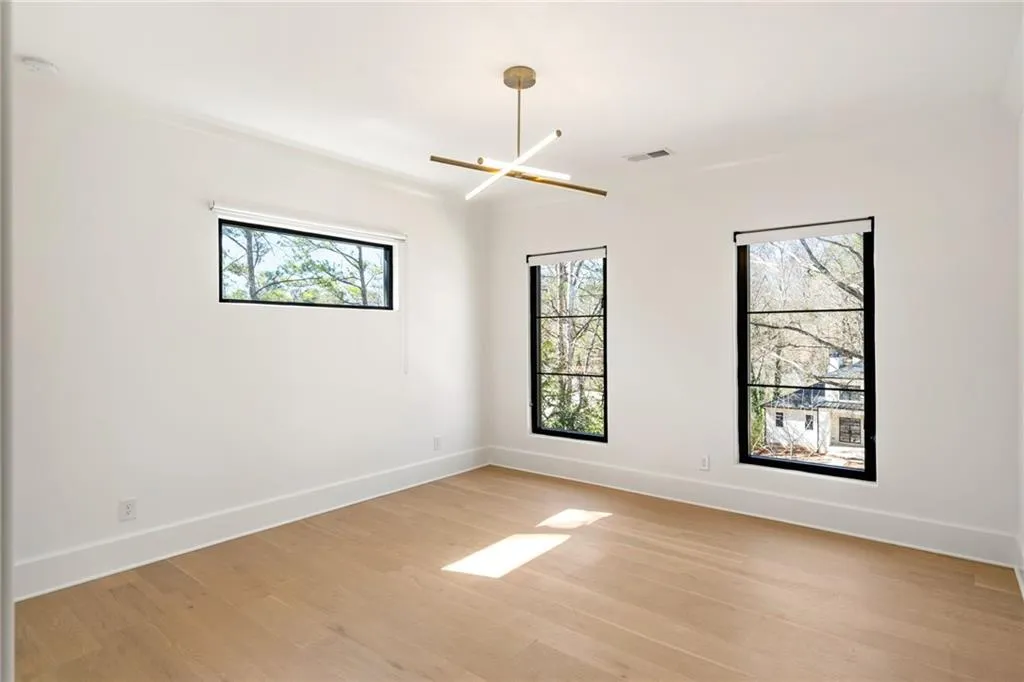Spare room featuring light wood finished floors, plenty of natural light, and baseboards