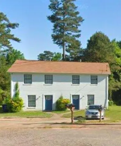 Two-story white exterior building with a brown roof