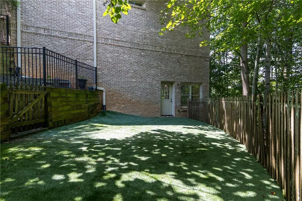View of side of property featuring brick siding and a patio