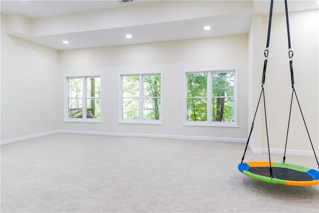 Playroom with healthy amount of natural light, light carpet, and recessed lighting