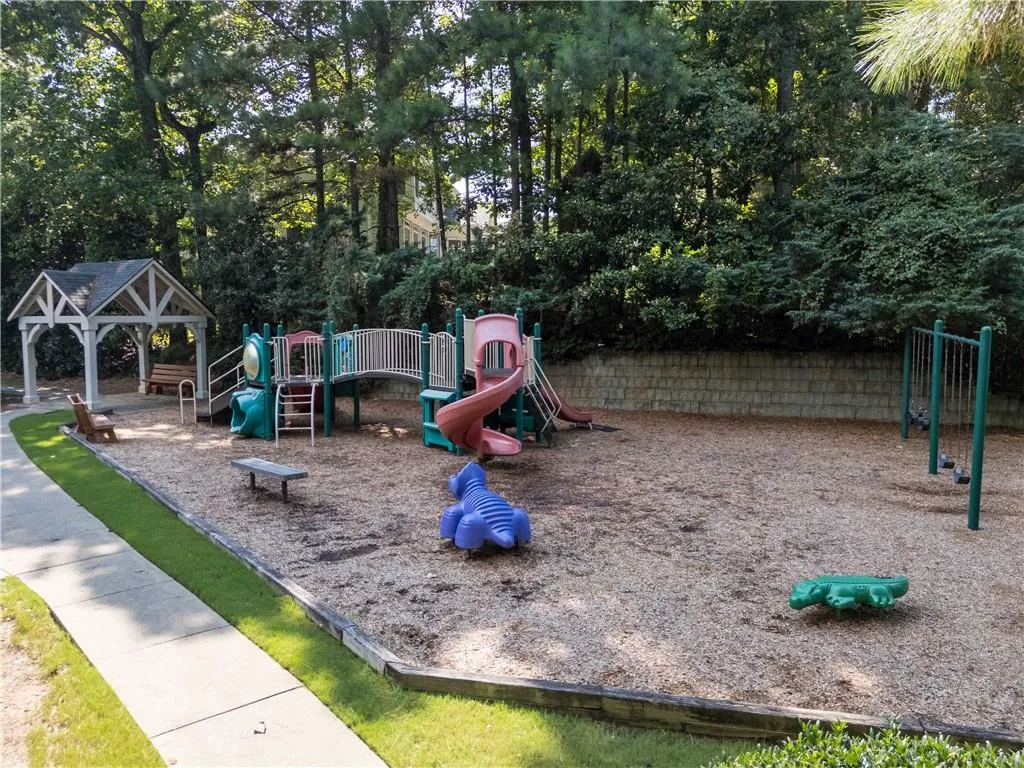Communal playground with a patio and view of scattered trees