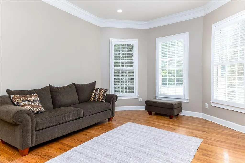 Living room featuring light wood finished floors, ornamental molding, and recessed lighting