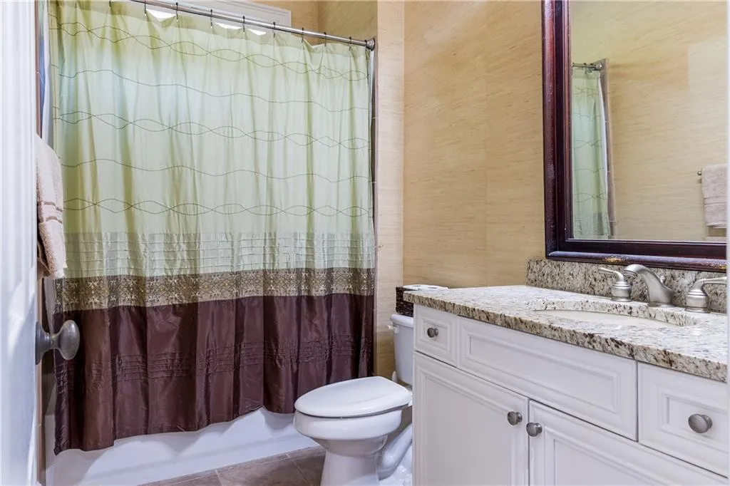 Full bathroom featuring shower / tub combo, vanity, tile patterned flooring, and wallpapered walls