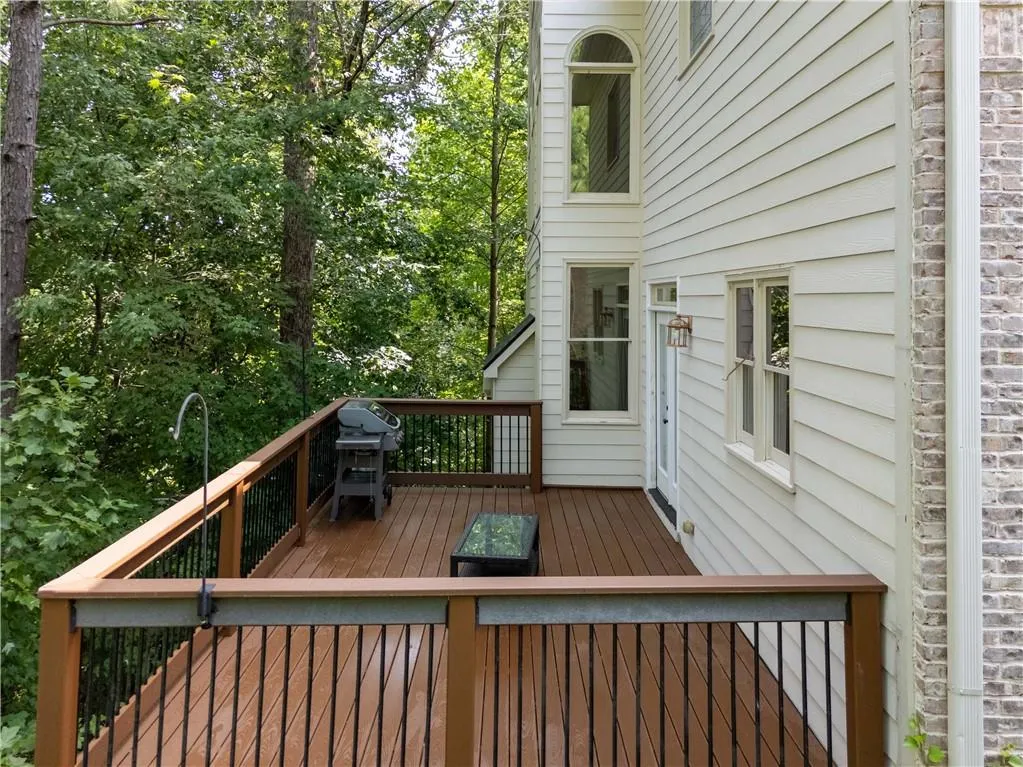 Deck featuring a grill and view of scattered trees