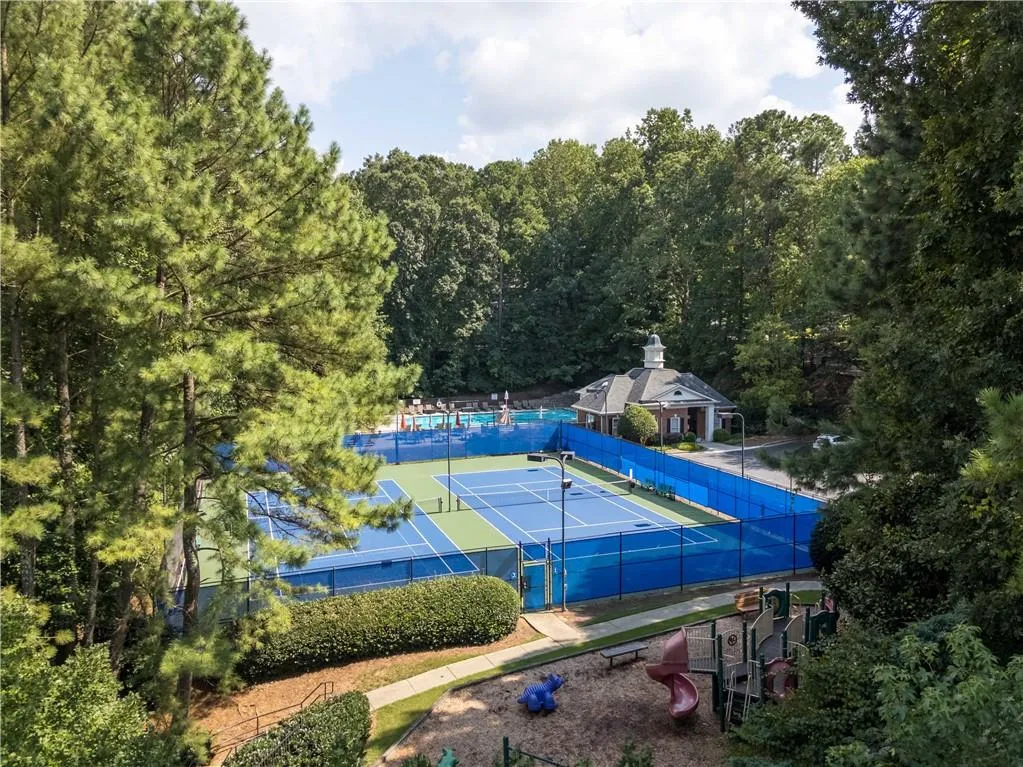 View of tennis court with a view of trees