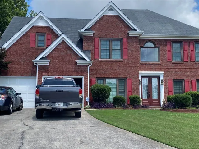 Red brick exterior with white trim accents and dark roof