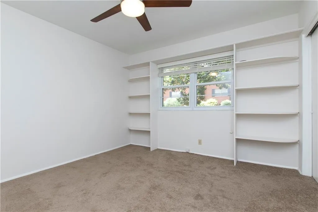 Empty room featuring carpet and a ceiling fan