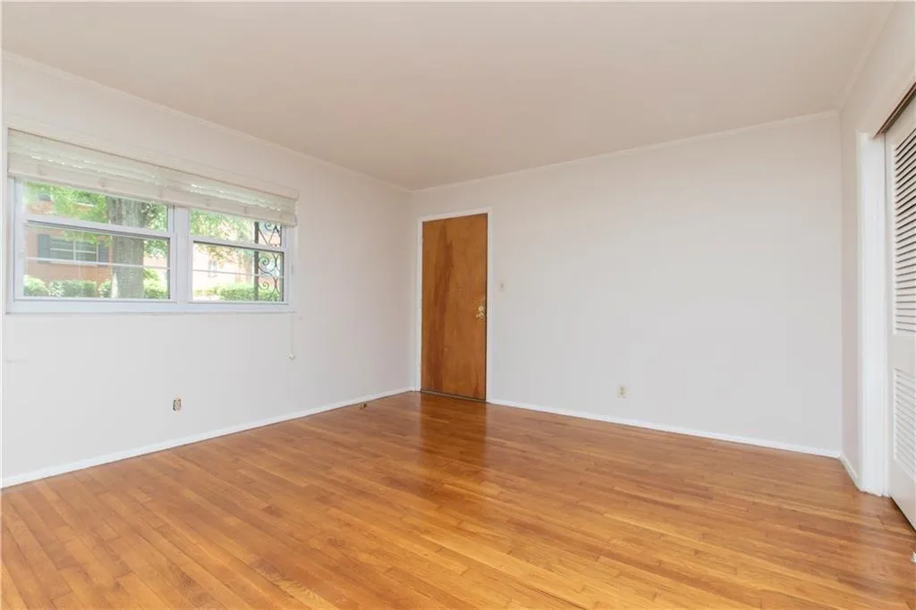 Unfurnished room featuring light wood-type flooring and ornamental molding