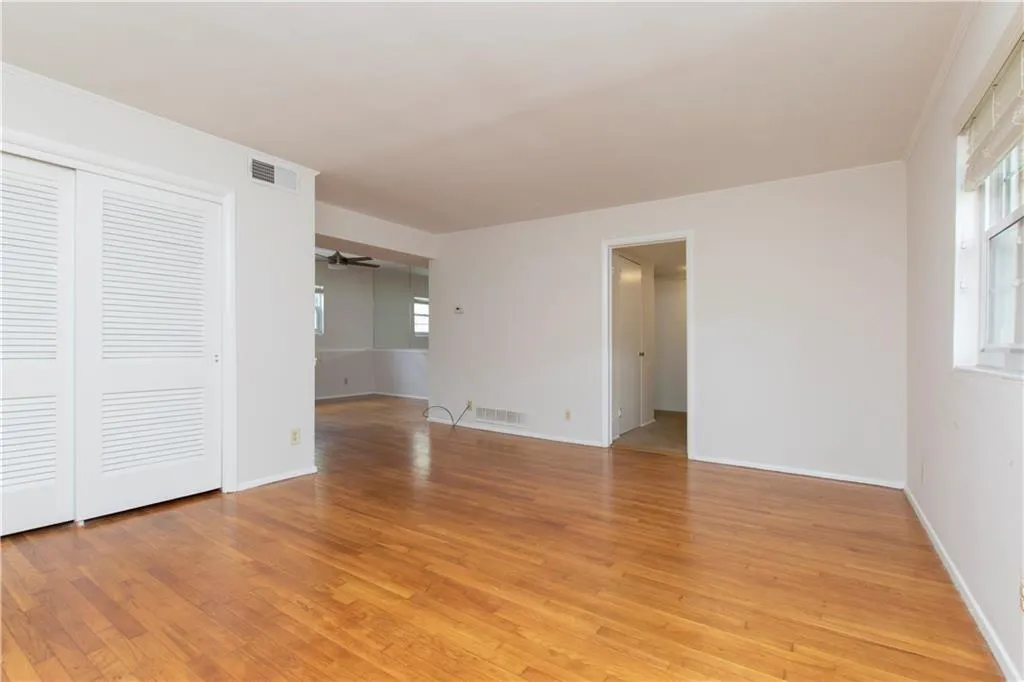 Unfurnished room featuring light wood-style flooring, ceiling fan, and healthy amount of natural light