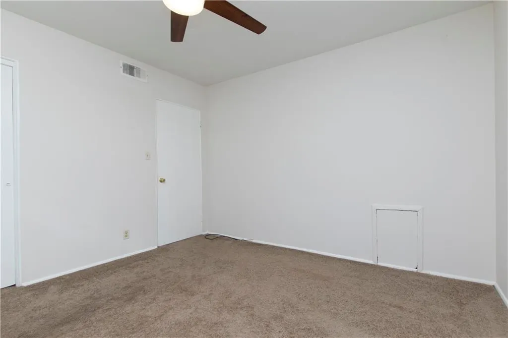 Carpeted spare room with baseboards and a ceiling fan