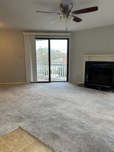 Unfurnished living room with carpet, a textured ceiling, and ceiling fan