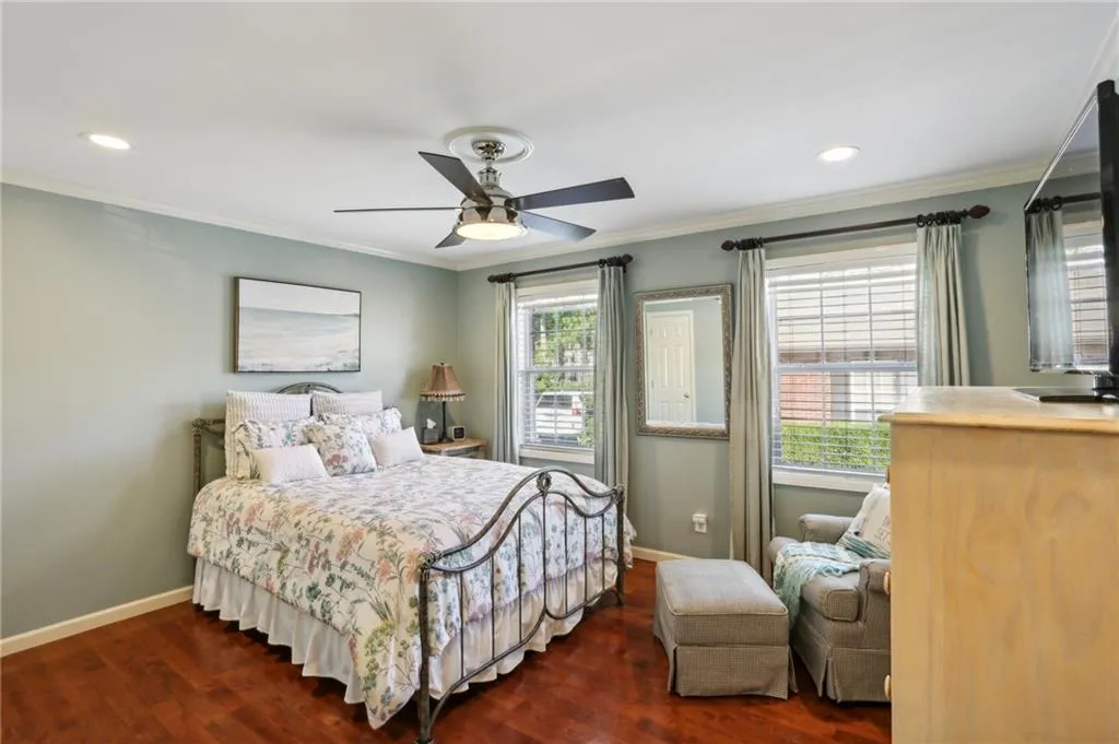 Bedroom featuring ceiling fan, dark hardwood / wood-style floors, and ornamental molding