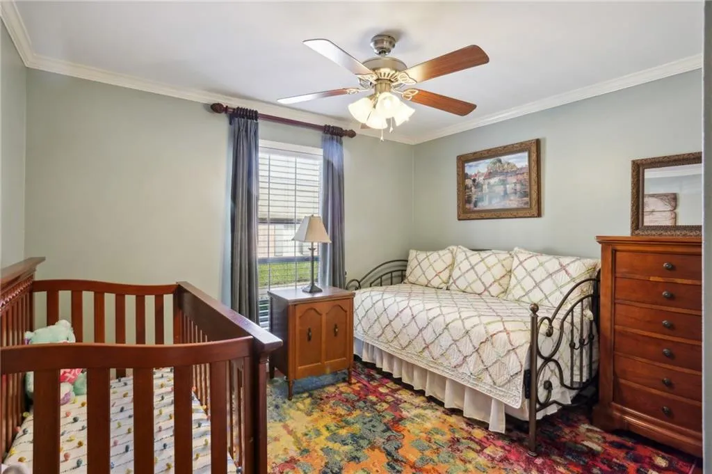 Bedroom featuring ceiling fan and ornamental molding