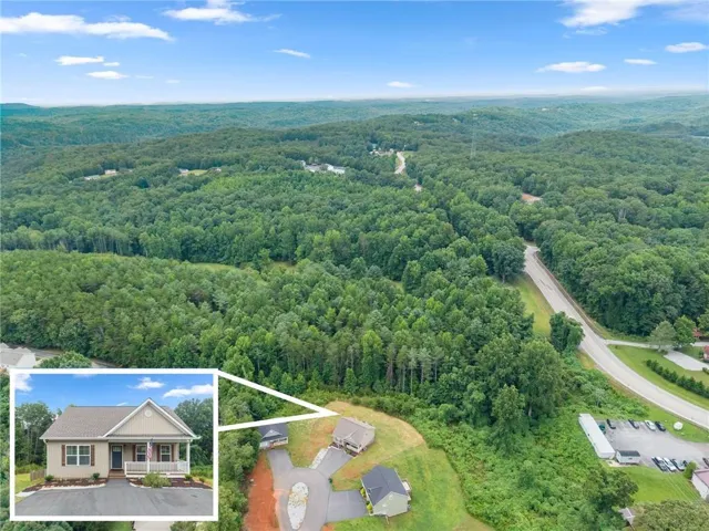 Aerial perspective showcasing a property surrounded by extensive wooded areas