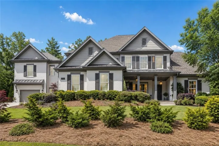 Contemporary colonial-style residence featuring a prominent gabled roofline and a light-colored brick facade