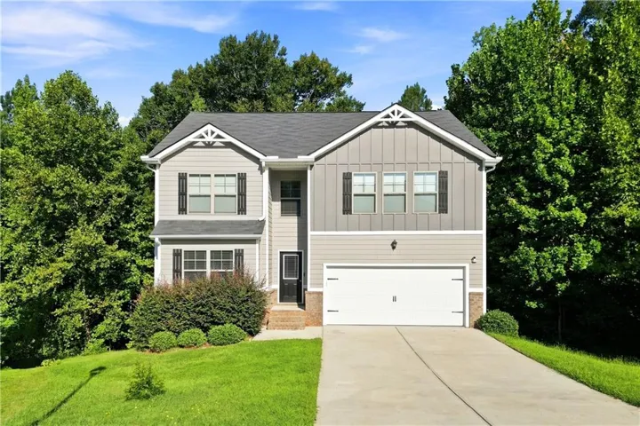 Two-story exterior with a shingled roof, board and batten siding, horizontal siding, attached two-car garage, and a concrete driveway