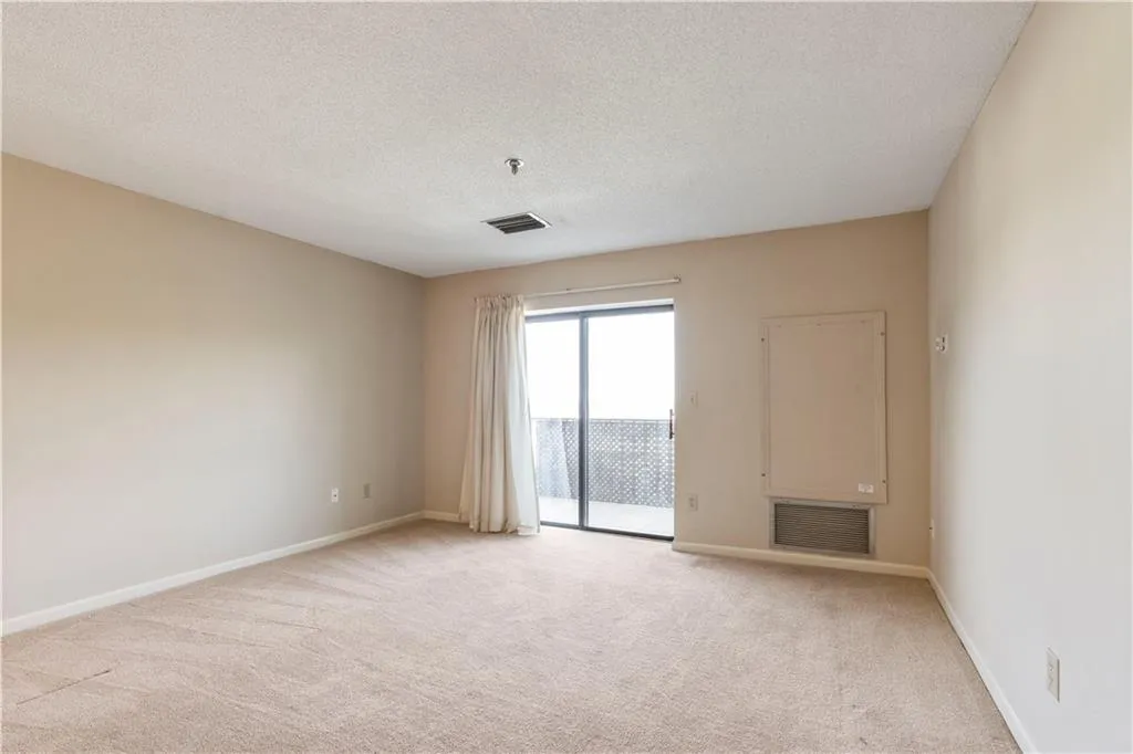 Living room featuring light colored carpet and a textured ceiling