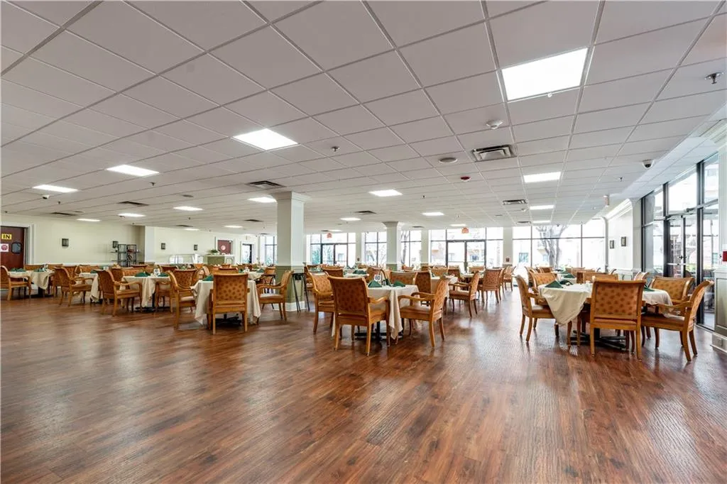 Dining area featuring ornate columns, dark hardwood / wood-style floors, a drop ceiling, and a wealth of natural light