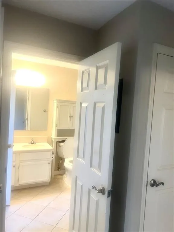 Bathroom with toilet, tile patterned flooring, and vanity