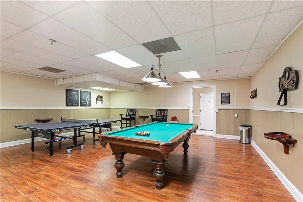 Rec room with a paneled ceiling and hardwood / wood-style floors