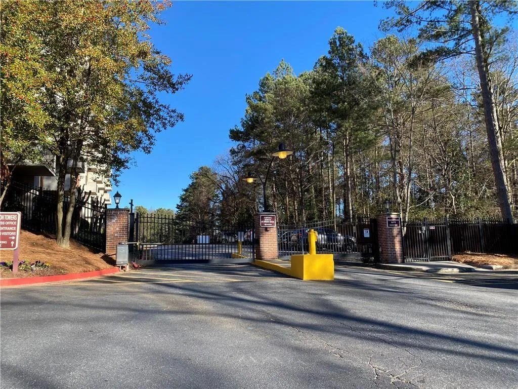 View of street with a gate, a gated entry, street lights, and curbs