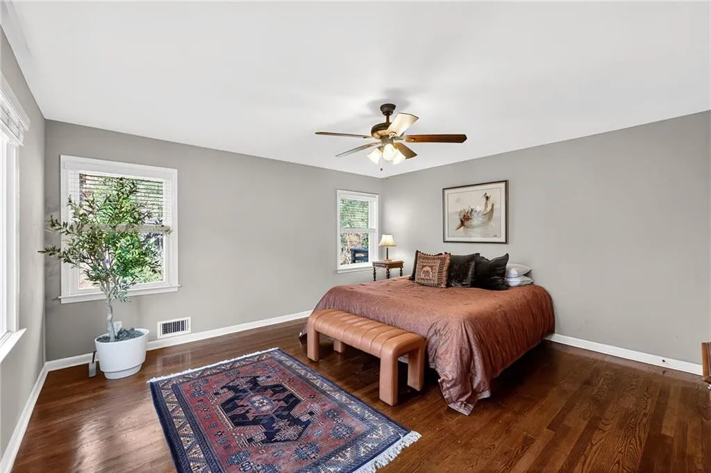 Alternate View of Primary Bedroom | Bright Natural Light | Gleaming Hardwood Floors | Neutral Paint | Custom Window Treatments