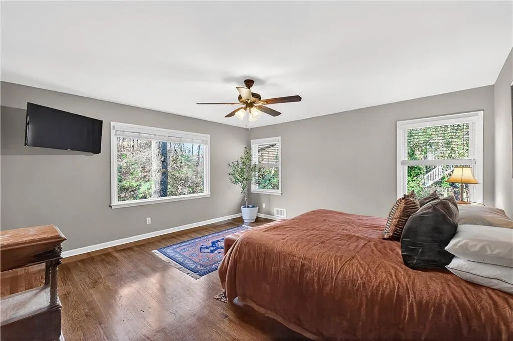 Sundrenched Main Floor Primary | Private Wooded Views | Gleaming Hardwood Floors | Fresh Neutral Paint