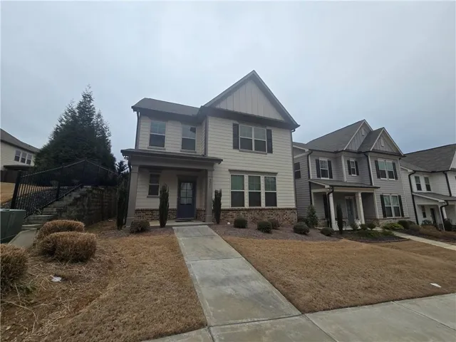 Craftsman-style home with covered porch, brick siding, and board and batten siding