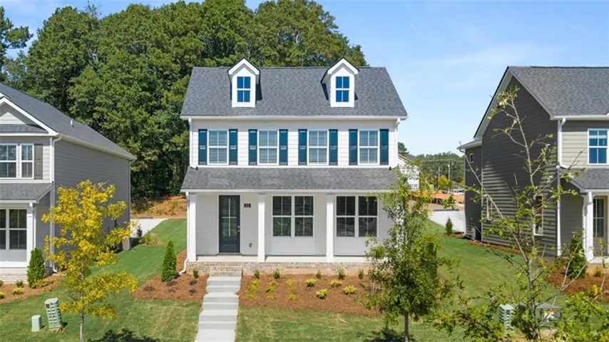 View of front of house with covered porch, roof with shingles, and a front yard