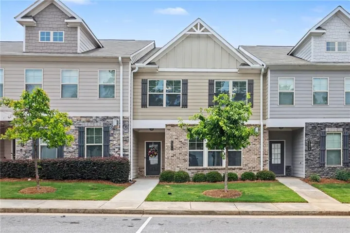 Contemporary townhome facade featuring a prominent gable accent