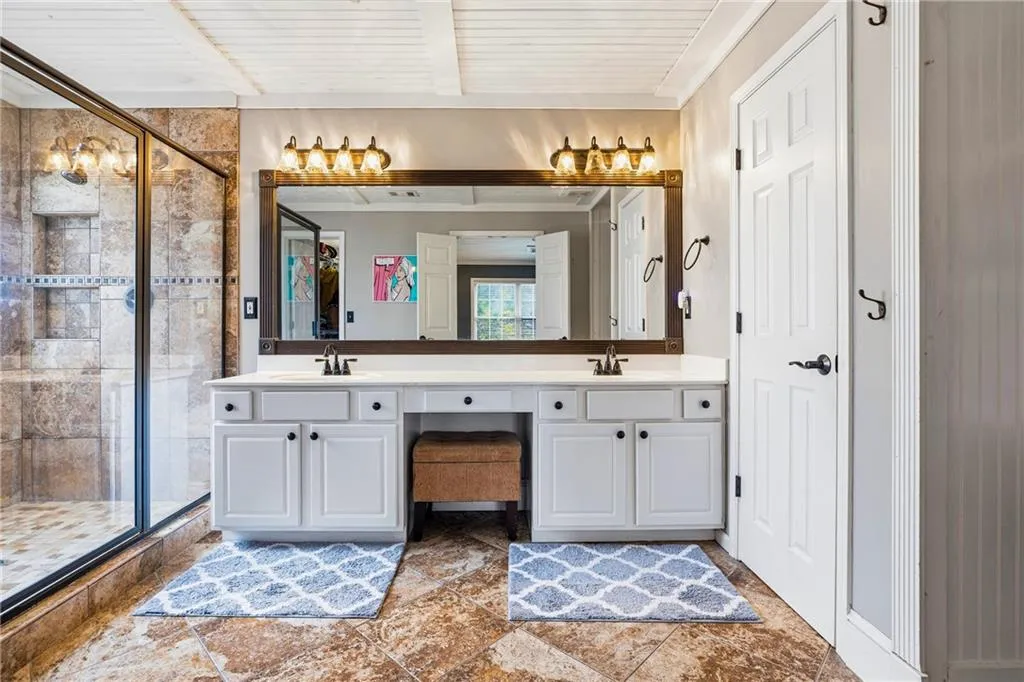 Dual vanity with white cabinetry, built-in makeup area, and individual sinks