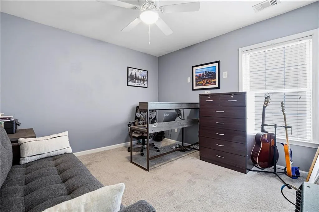 Wall-to-wall carpeting, ceiling fan, and window with blinds