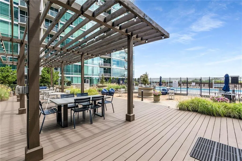 Deck with a community pool, a pergola, outdoor dining space, and a patio