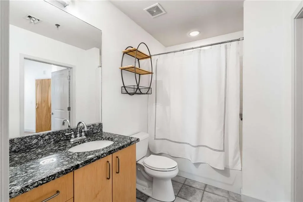 Bathroom with vanity, shower / bathtub combination with curtain, light tile patterned floors, and recessed lighting