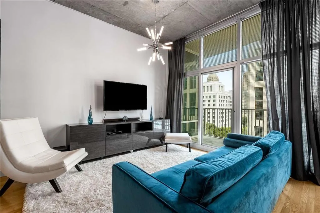 Living area with light wood-style flooring, a chandelier, and expansive windows