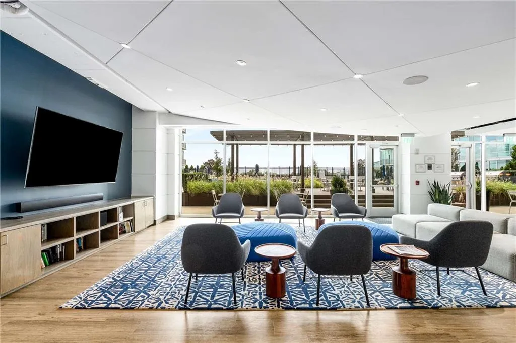 Living room with expansive windows, light wood-type flooring, plenty of natural light, and recessed lighting