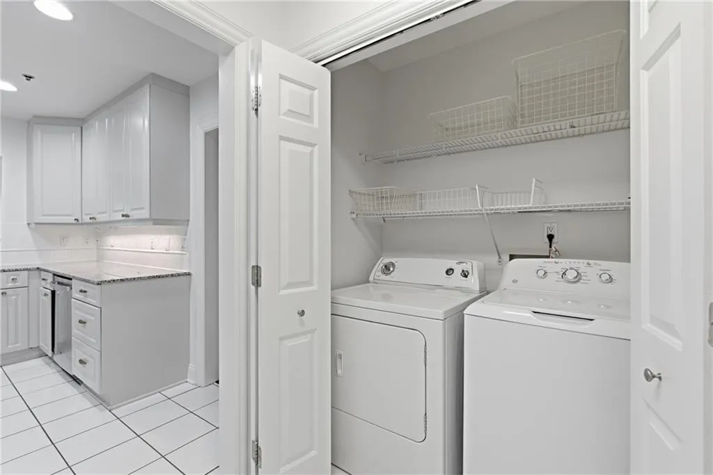 Dedicated laundry closet featuring a stacked washer and dryer, wire shelving, and bifold doors