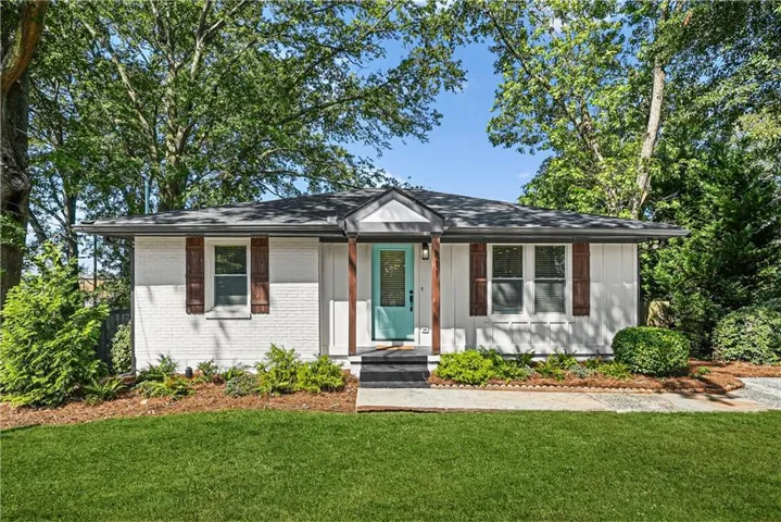 White brick and board-and-batten siding exterior with a dark shingle roof