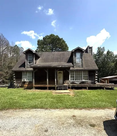Log cabin style exterior with a gabled roof and two dormer windows