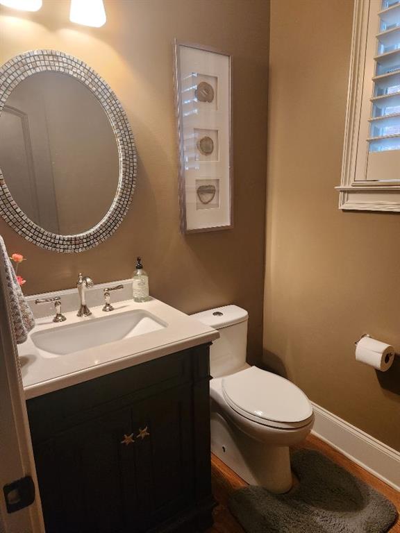 Bathroom featuring toilet and vanity with extensive cabinet space
