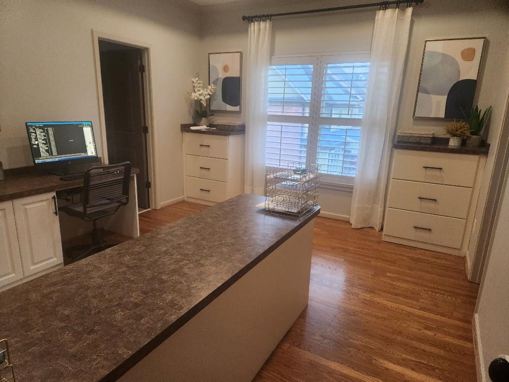 Kitchen featuring hardwood / wood-style floors and white cabinets