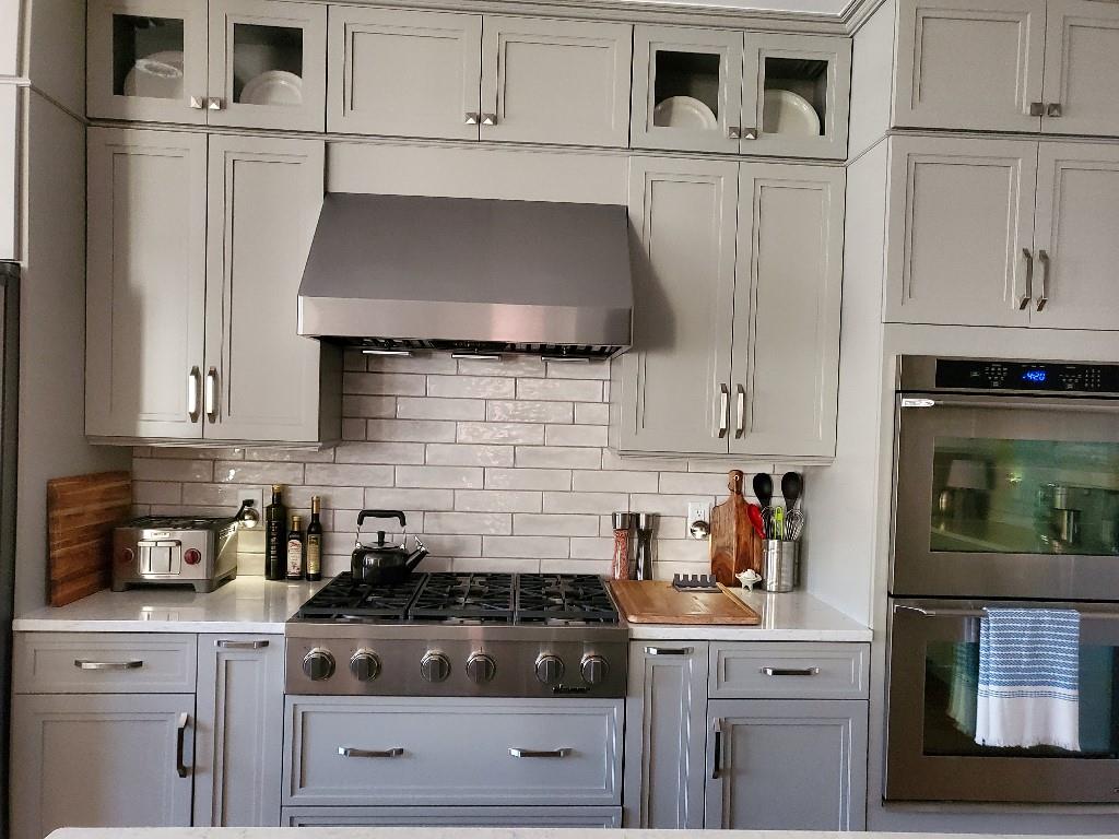 Kitchen featuring tasteful backsplash, wall chimney exhaust hood, and appliances with stainless steel finishes