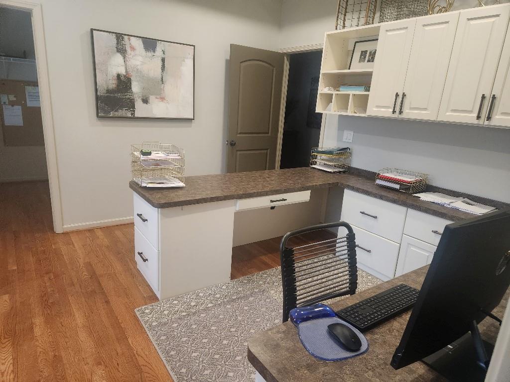 Kitchen featuring white cabinetry, light hardwood / wood-style floors, and built in desk