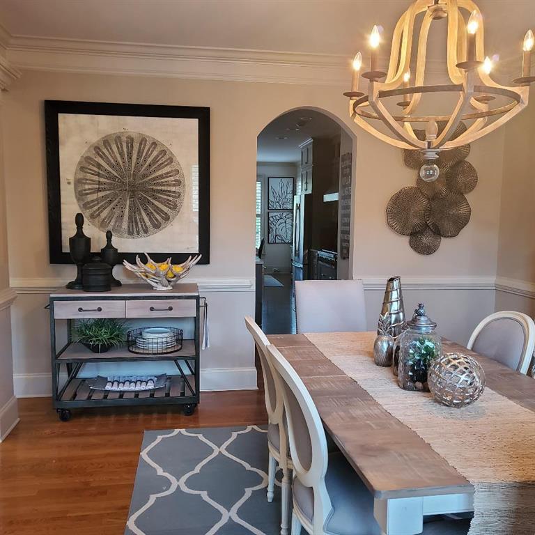 Dining area featuring crown molding, a notable chandelier, and dark wood-type flooring