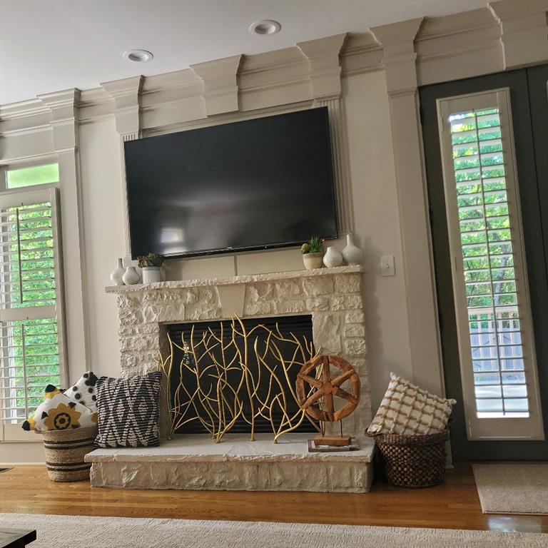 Room details with wood-type flooring and a stone fireplace